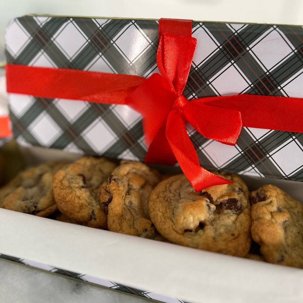 10 homemade chocolate chip & macadamia nut cookies in a festive Christmas tin